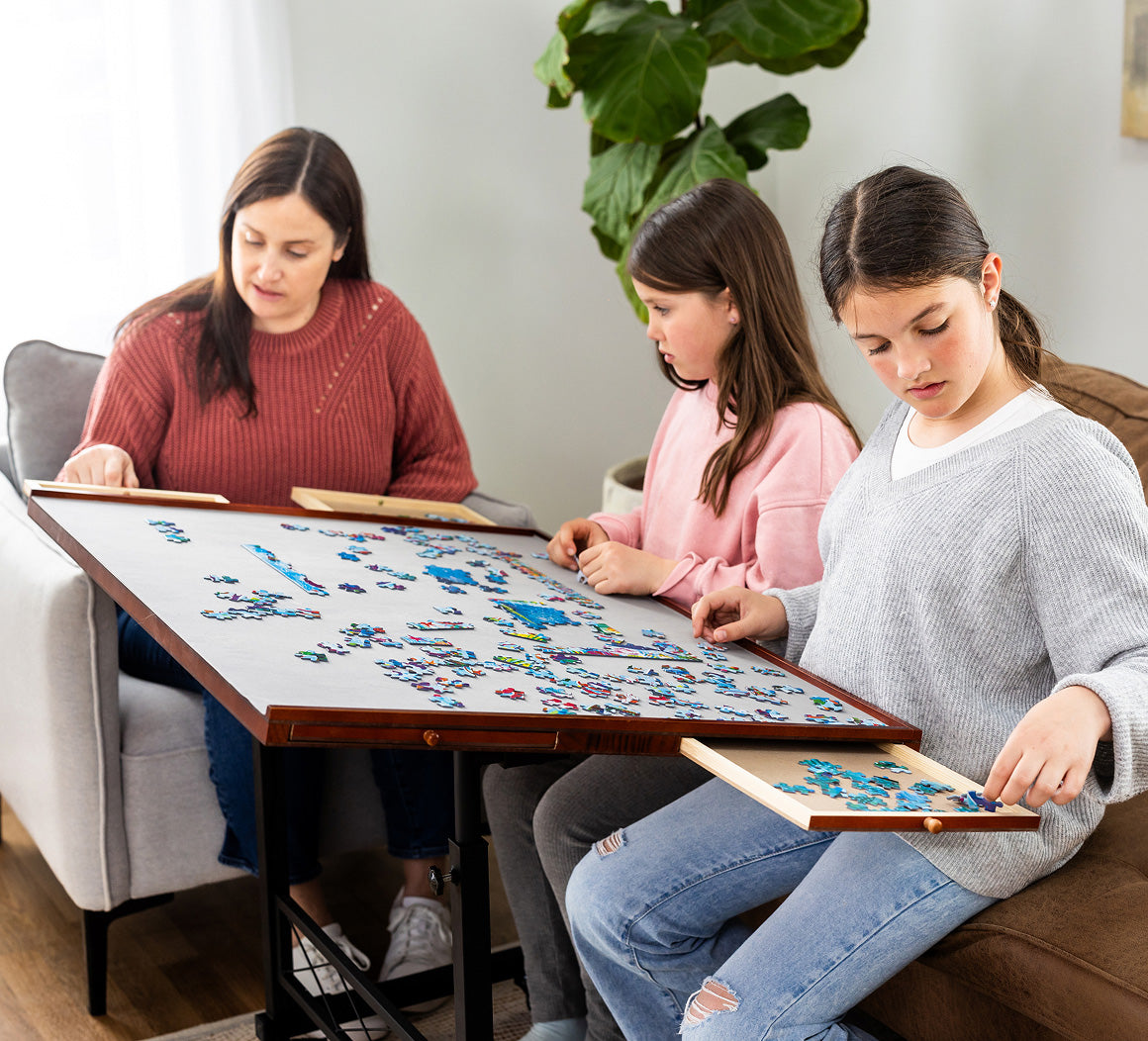 Three women working on a puzzle together in a cozy living room.